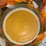 Whole Pumpkin Chiffon Pie with fall leaves in background.