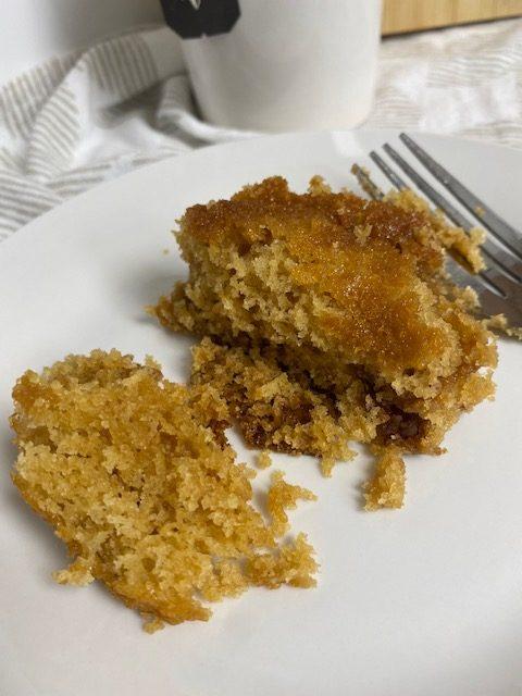 Slice of cinnamon crumb cake on white plate with fork