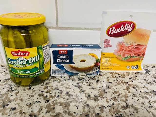Jar of pickles, block of cream cheese, and package of ham