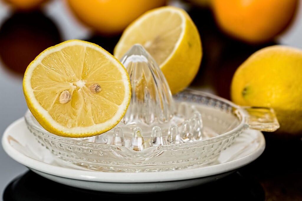Half of a lemon sitting in a glass citrus juicer.
