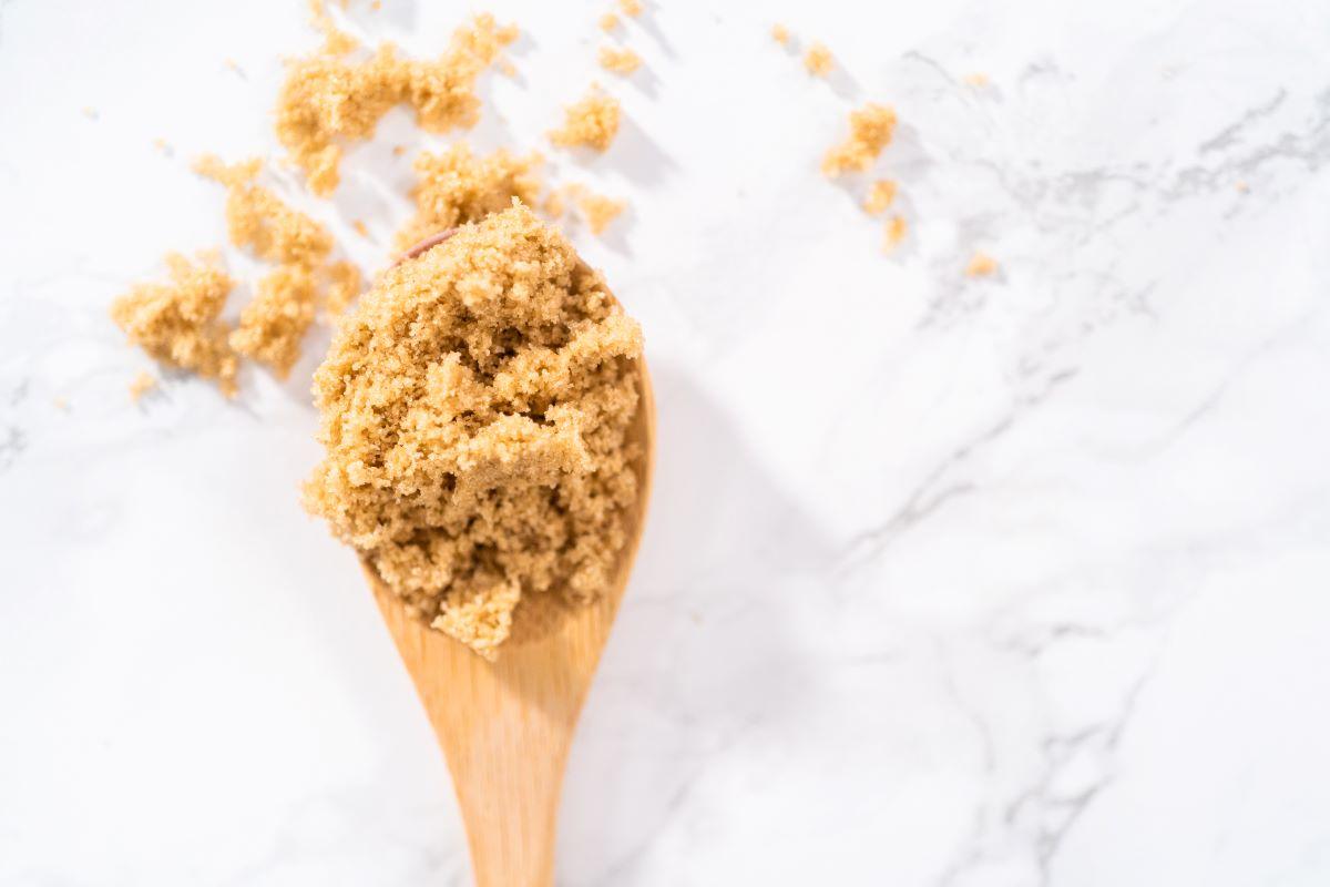 Brown sugar on wooden spoon.