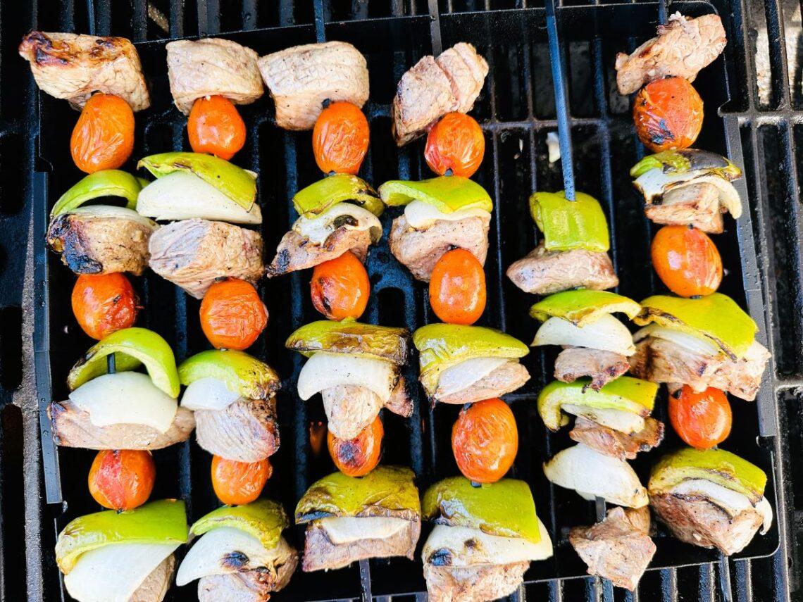 Cooked beef kabobs on grill.