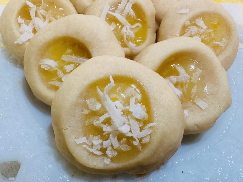 Close up of lemon puff cookies on white plate.