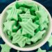 Green star-shaped mints in white bowl.