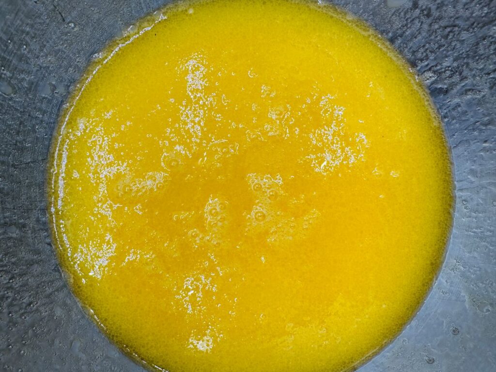Yellow liquid in silver bowl.