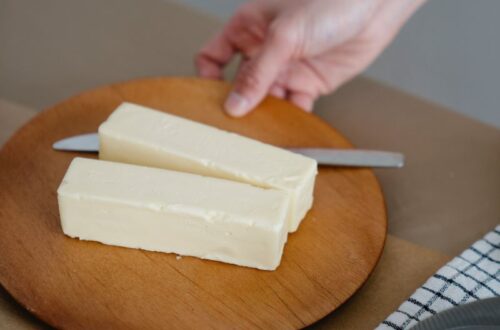 Sticks of butter on round wooden board.
