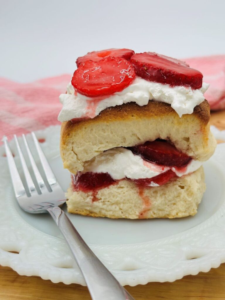 Strawberry shortcake on white plate with fork.