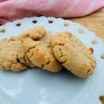 Three peanut butter cookies on white plate.