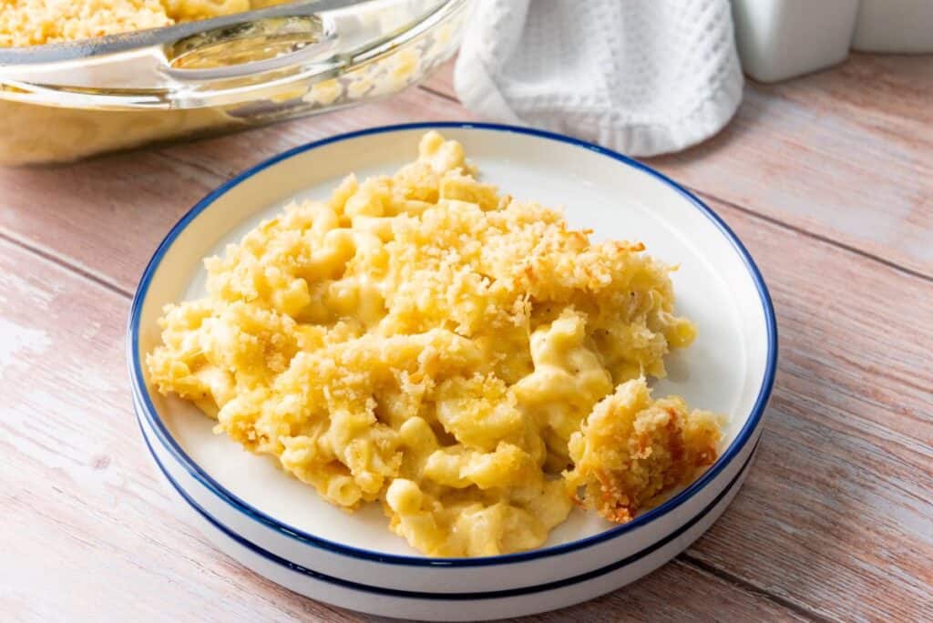 One serving of macaroni and cheese on round white plate.