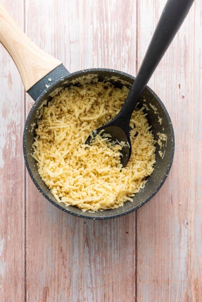 Crumbs and shredded cheese in gray pot.
