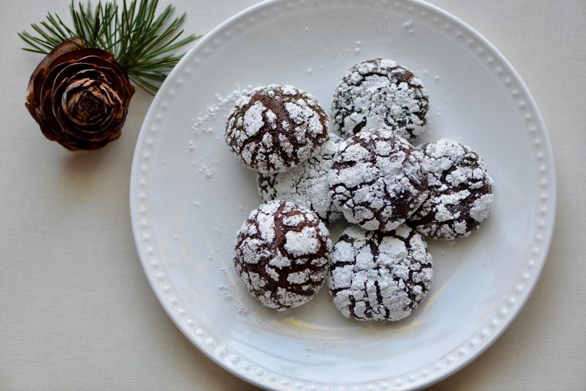 Chocolate crinkle cookies on round white plate.