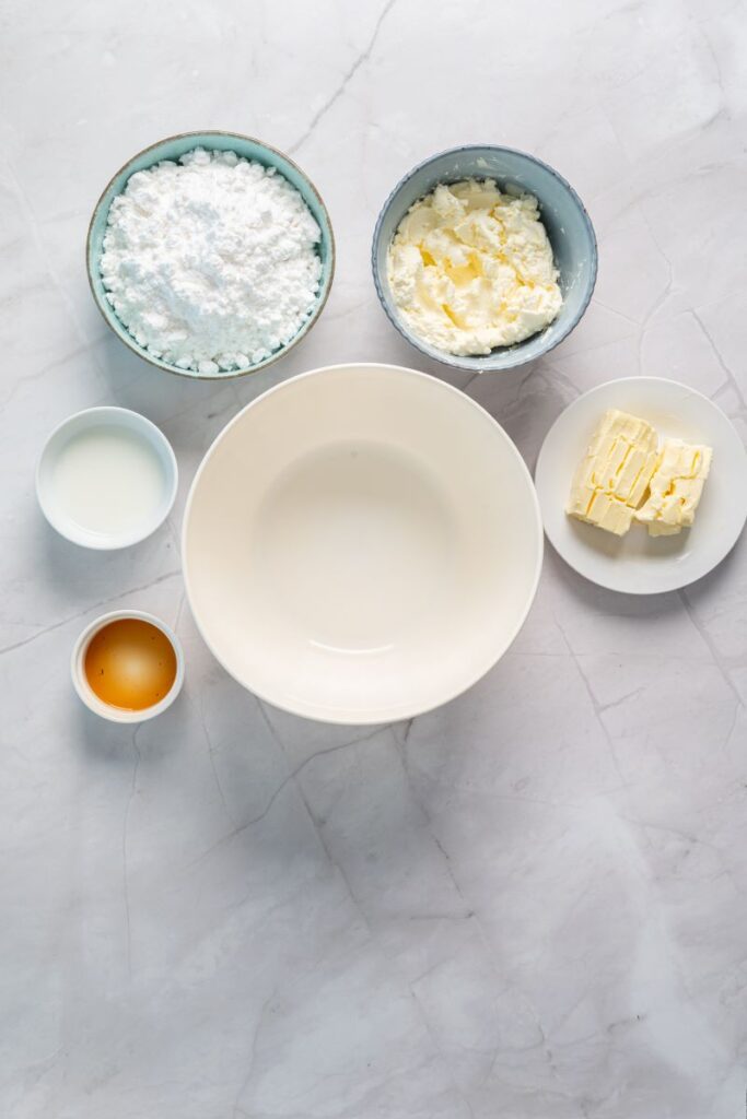 Top view of ingreditns for cream cheese frosting in white bowls.