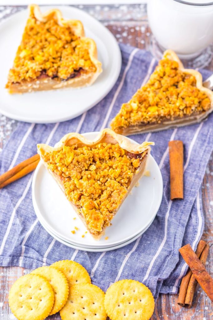 Top view of slice of pie on white plate with two pie slices in the background.