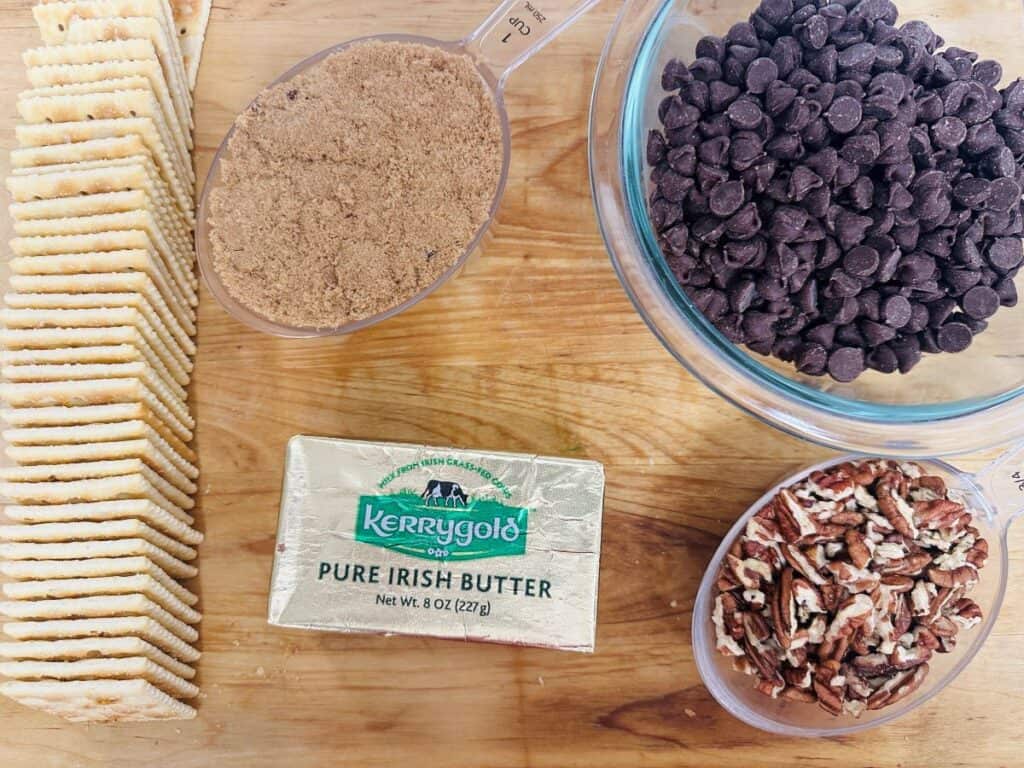 Ingredients for saltine toffee on wooden board.