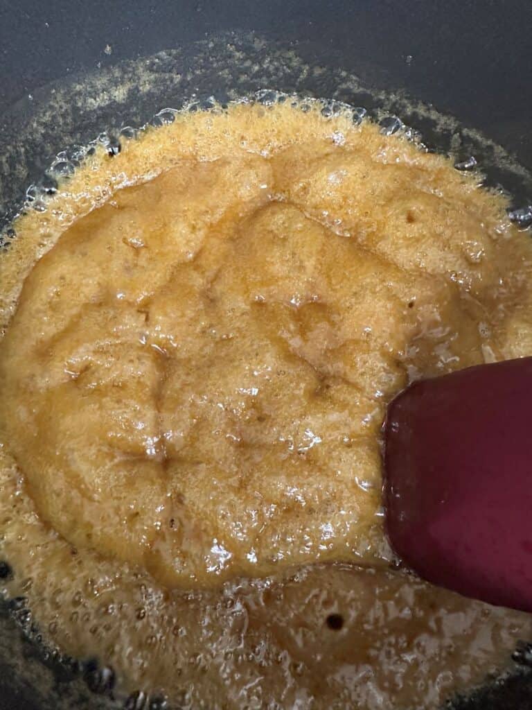 Brown sugar and butter boiling in saucepan.