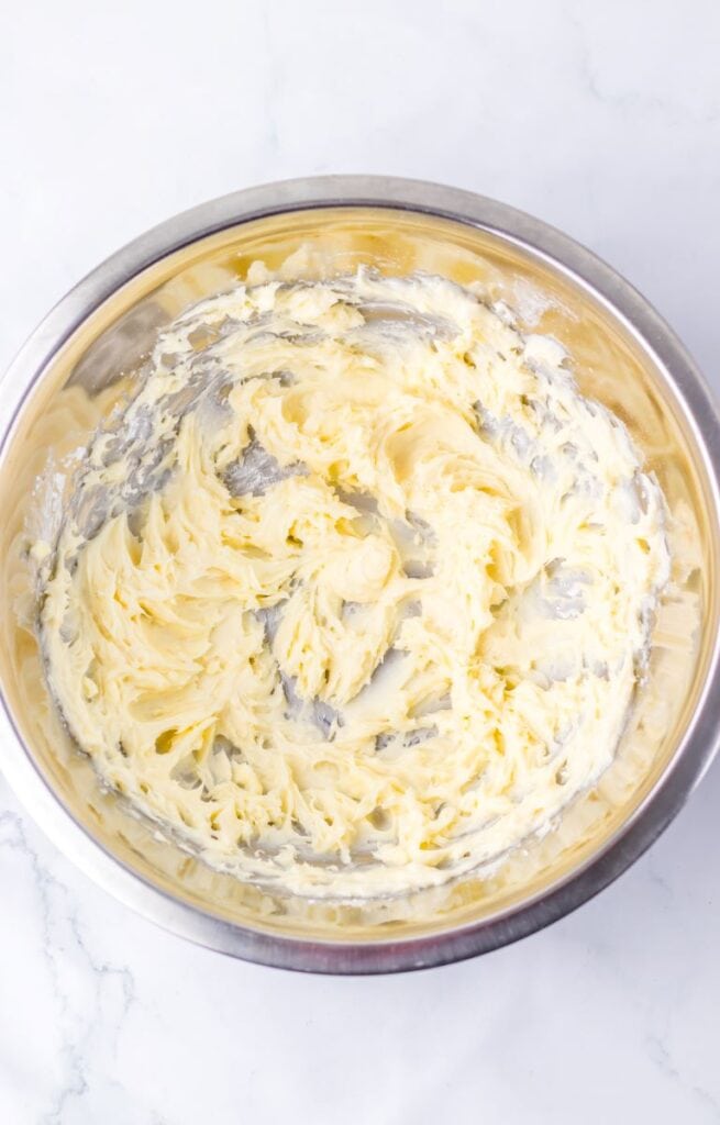 Light yellow frosting mixture in silver bowl.