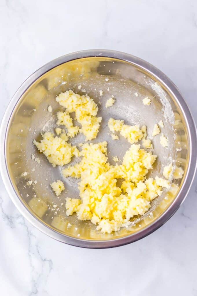 Yellow creamed butter and sugar in silver bowl.