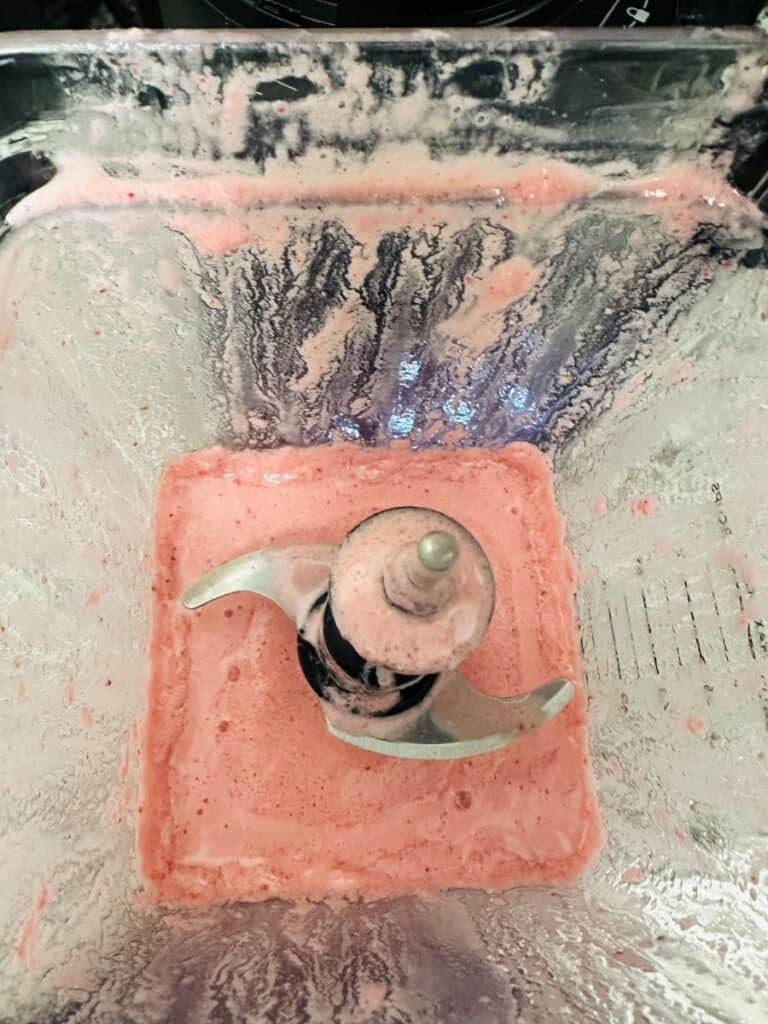 Top view of blended pink mixture in a blender.