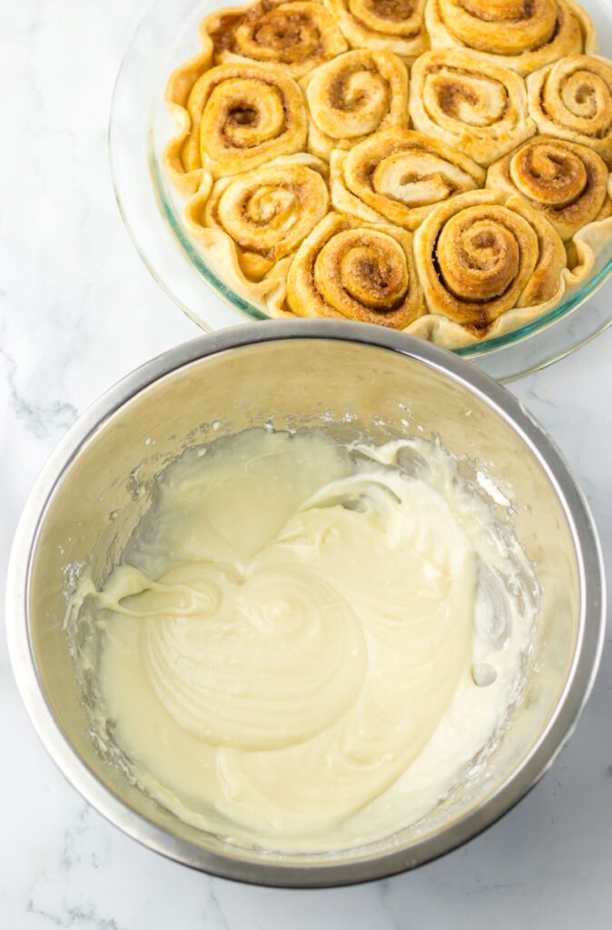 Top view of white frosting in silver bowl.