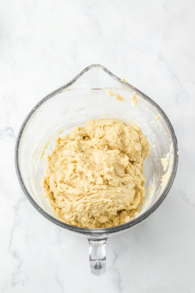 Ball of dough in glass measuring cup.