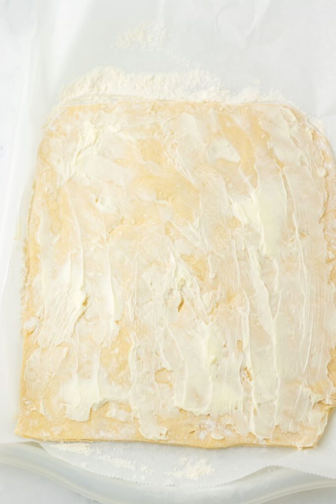 Rectangle of flattened dough with butter on top.