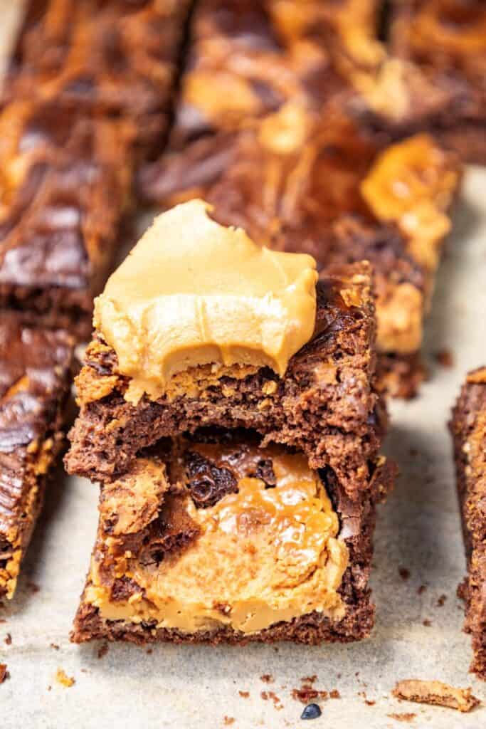 Close up of two chocolate peanut butter brownies with more in the background.