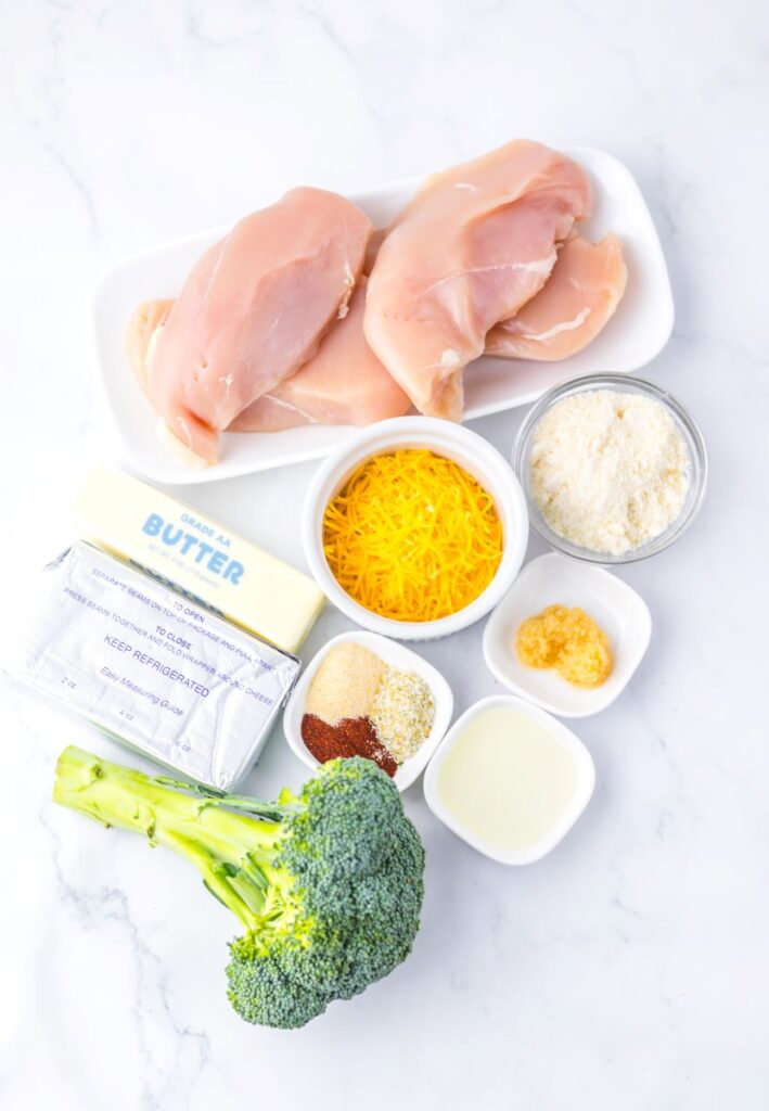 Ingredients for Broccoli and Cheese Stuffed Chicken on white background.