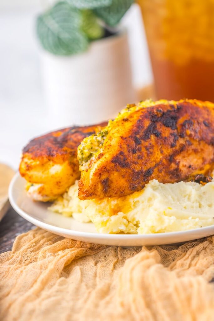 Close up of cooked chicken on mashed potatoes.