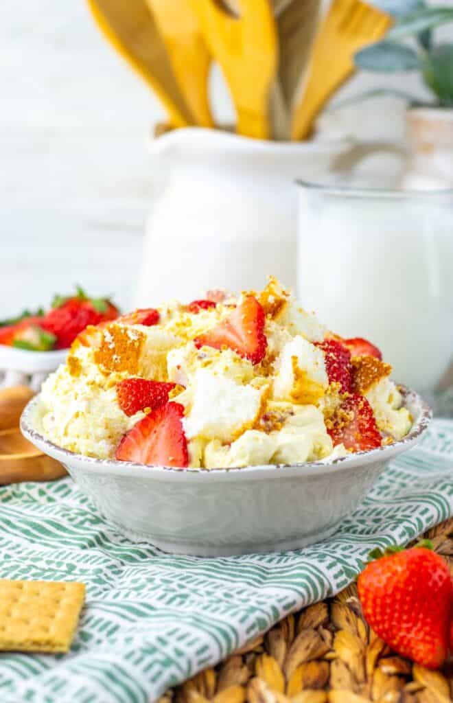 Side view of completed strawberry shortcake fluff salad in white bowl.