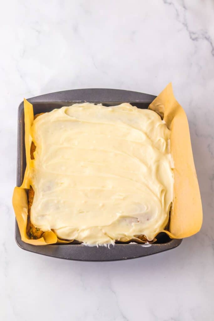 Top view of square cake with white frosting.