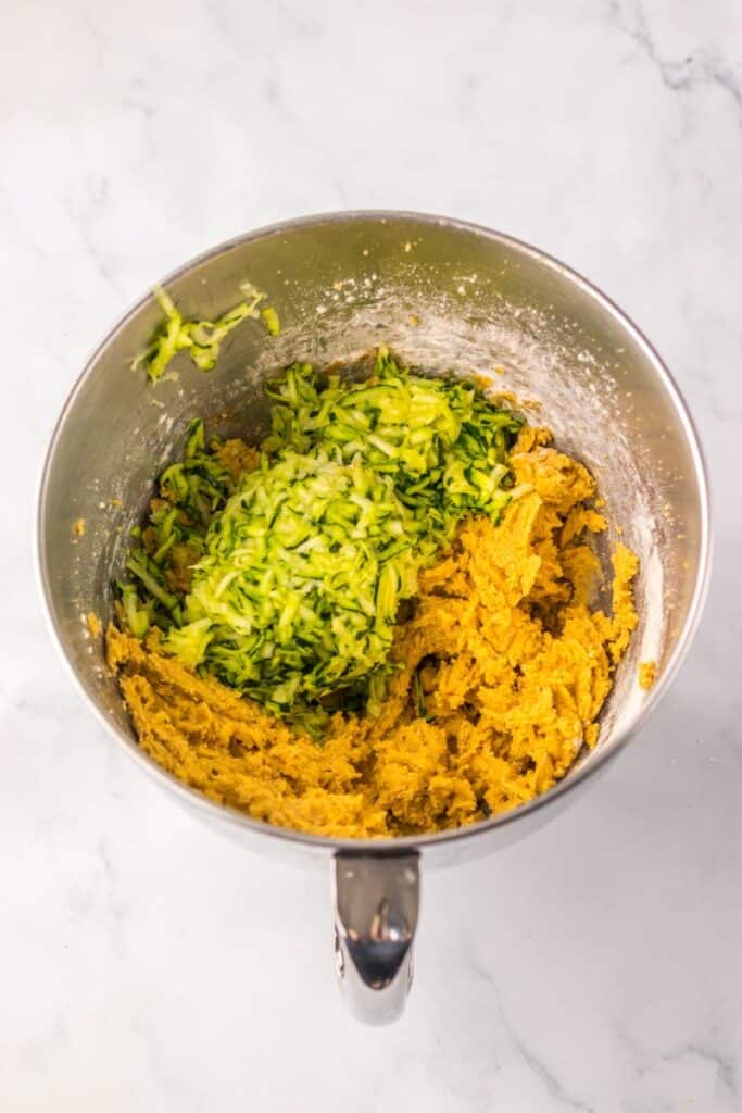 Silver bowl with shredded zucchini and light brown mixture.