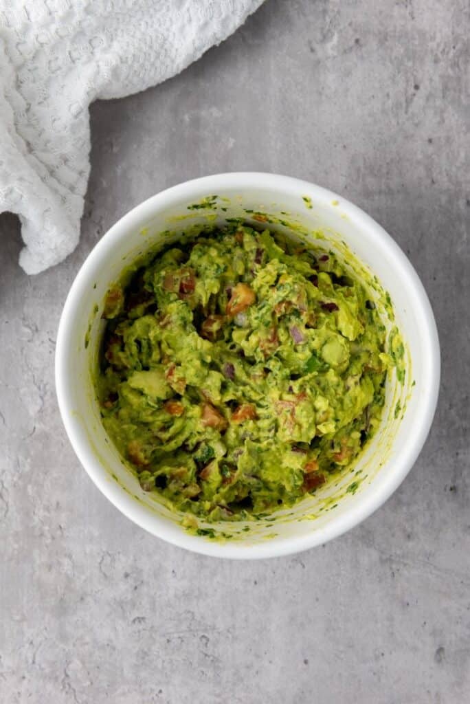 Green mixture of ingredients in white bowl.