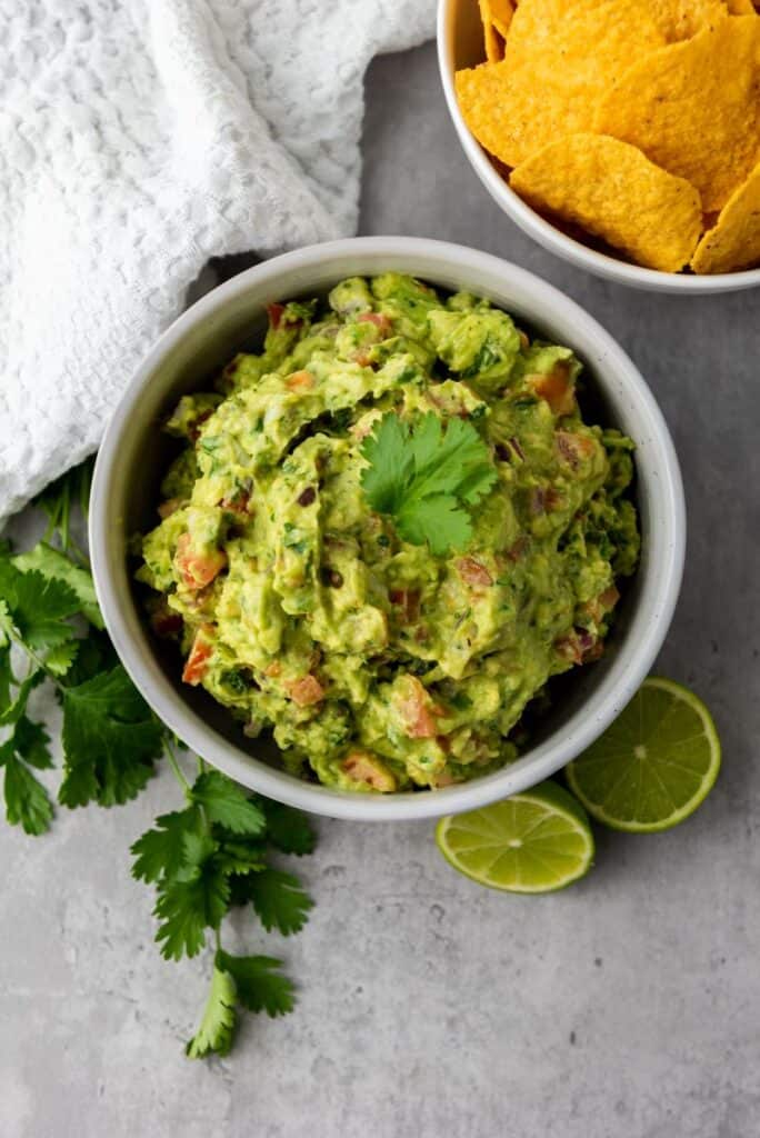 Top view of white bowl of green guacamole.