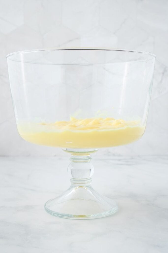 Side view of clear trifle bowl with one layer of banana pudding.