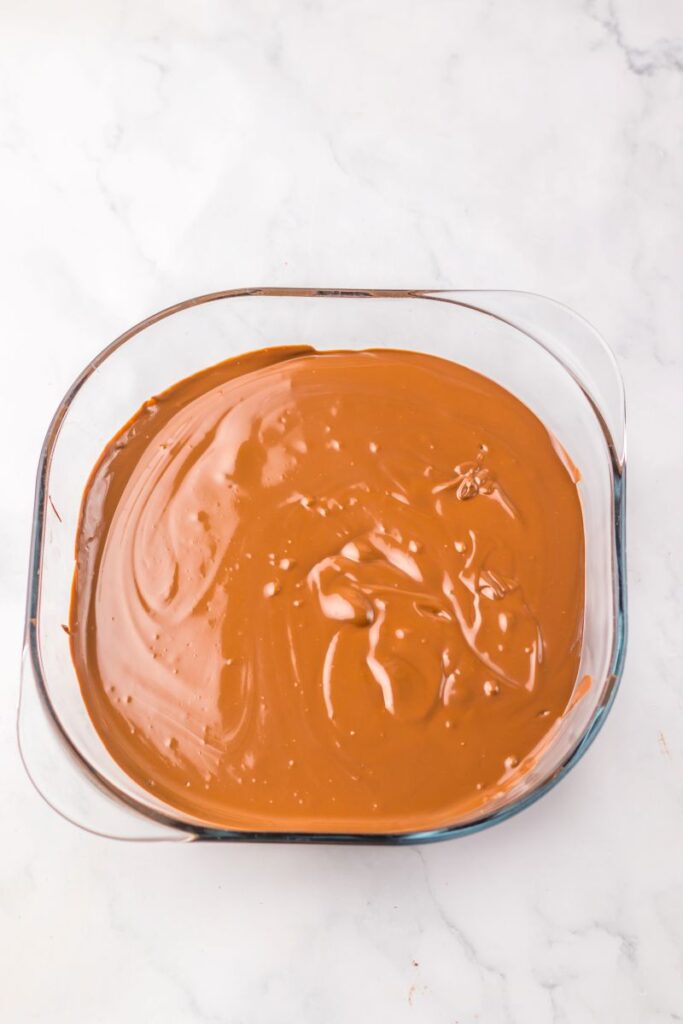 Overhead view of melted chocolate in glass dish.