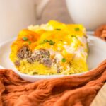 Close up of one serving of breakfast casserole on white plate.
