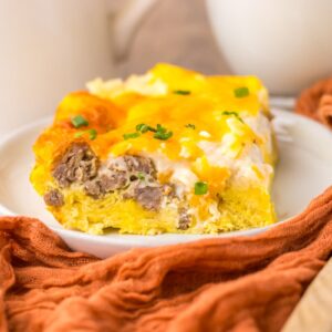 Close up of one serving of breakfast casserole on white plate.