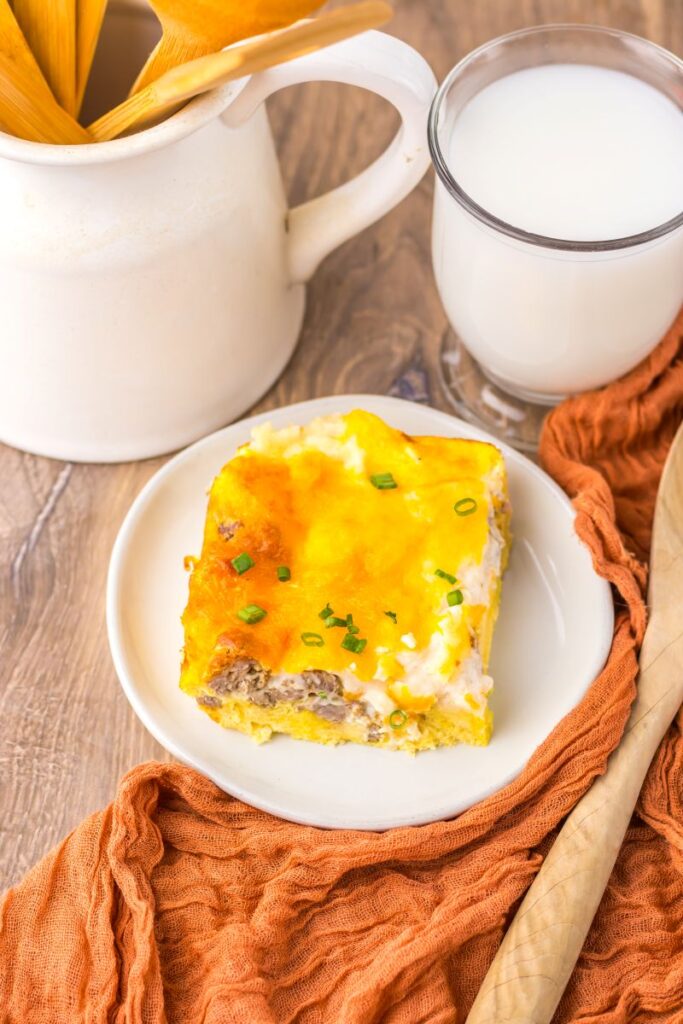 Overhead view of one serving of breakfast casserole on white plate.