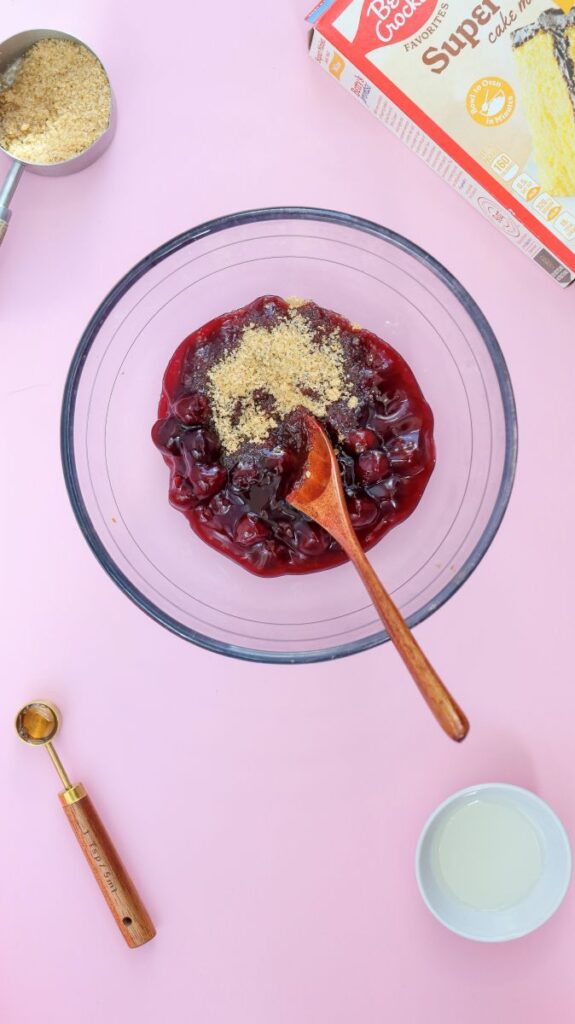 Overhead view of glass bowl with cherries and brown sugar.