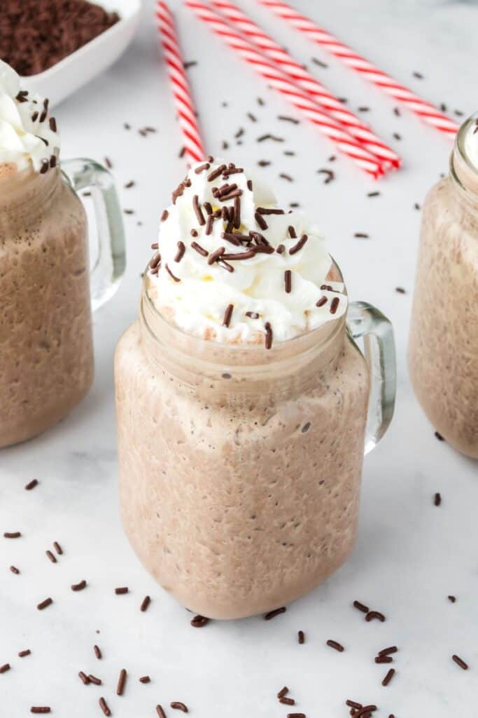 Chocolate milkshake with whipped cream and chocolate sprinkles.