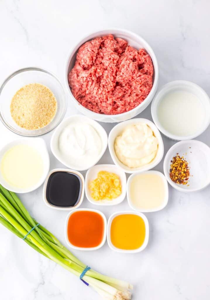 Ingredients for firecracker meatballs in small white dishes on white background.