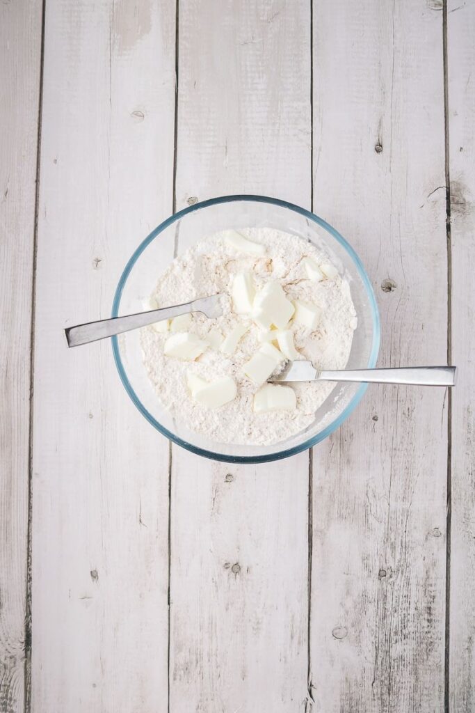 Overhead view of glass bowl with flour and shortening.