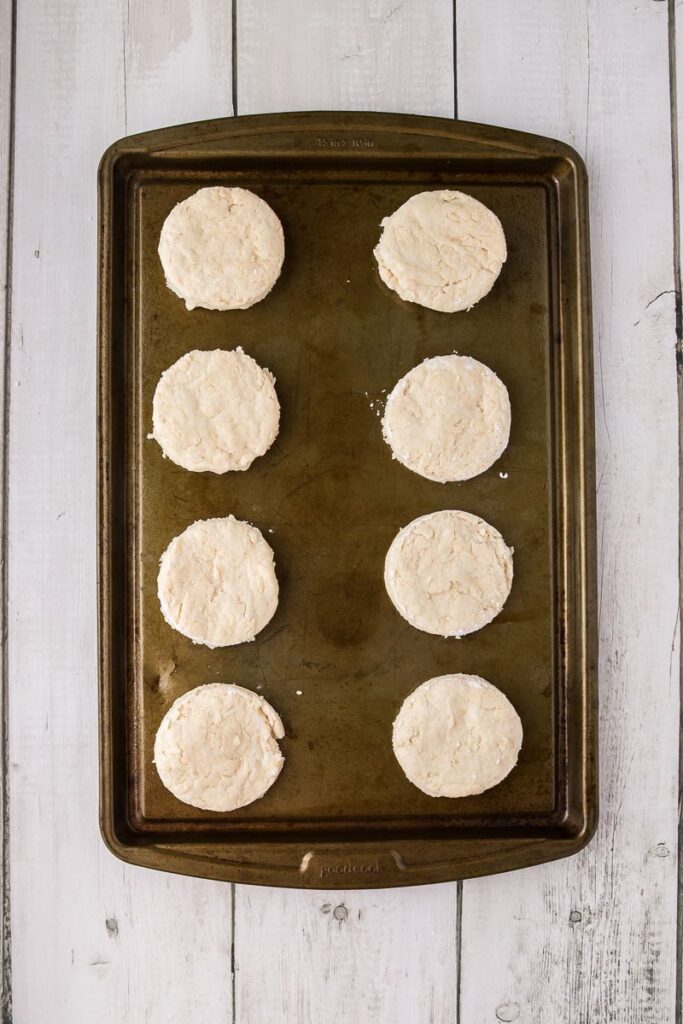 Overhead view of circles of bread dough on cookie sheet.