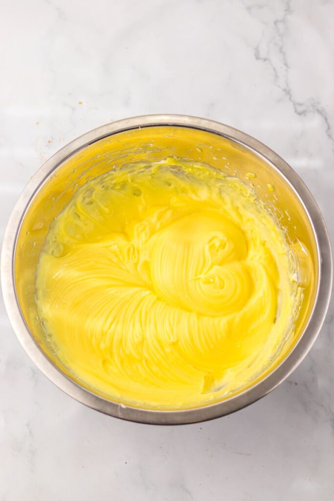 Thick yellow mixture in silver bowl.