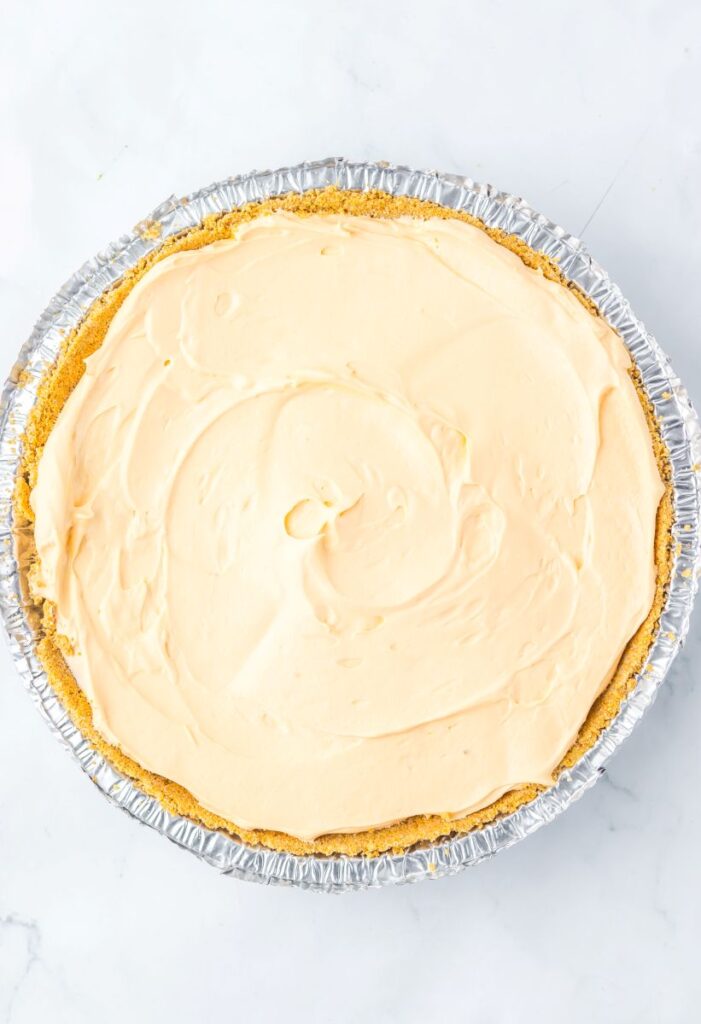 Overhead view of light orange pie in round tin.
