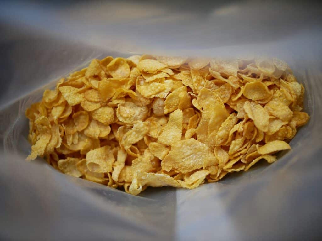 Cornflakes cereal at the bottom of a clear bag.