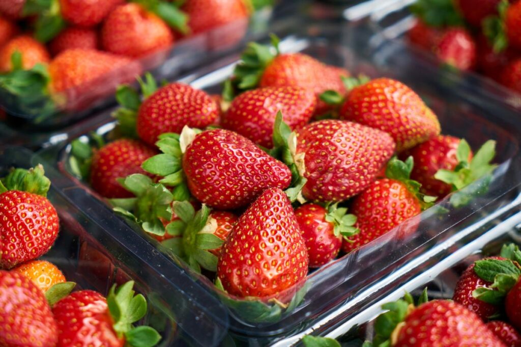 Close up of strawberries in clear plastic containers.