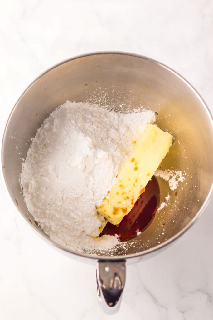 Silver bowl with white powder, stick of butter, and brown liquid.