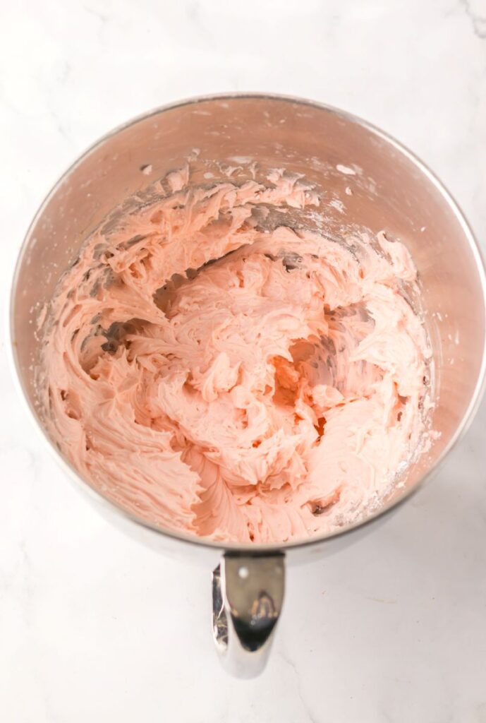 Overhead view of silver bowl with pink frosting.