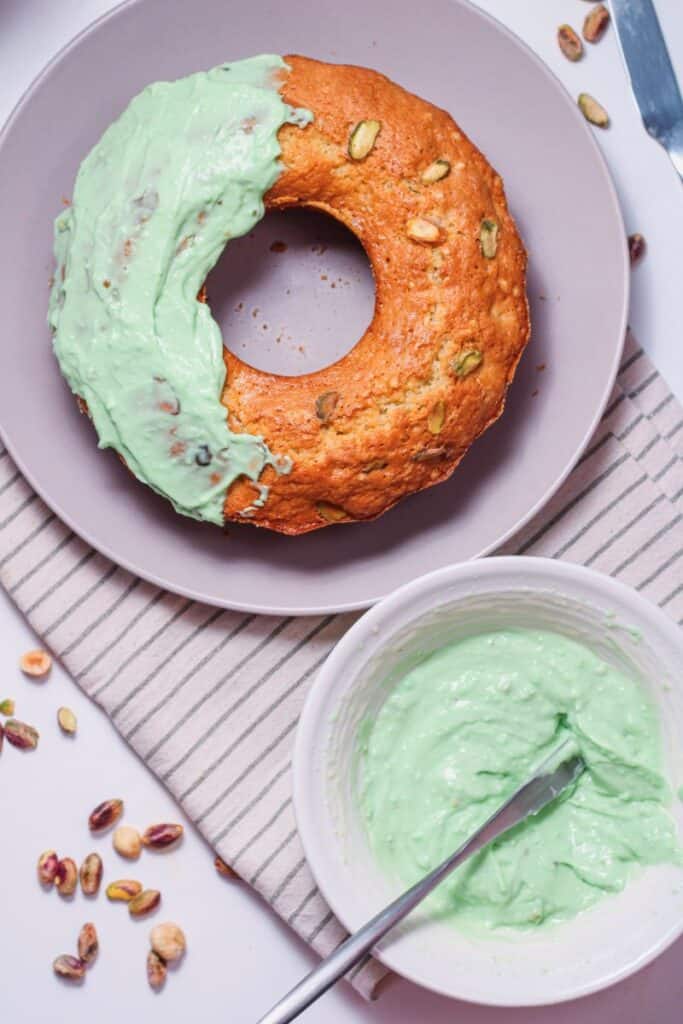 Overhead shot of pistachio bundt cake with green frosting.